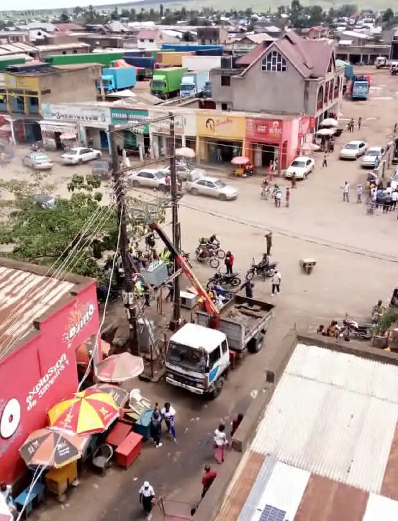 The girls enter the doors of a blue bus that has arrived at the bus stop.